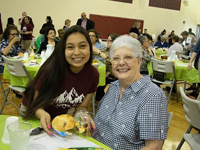 Student serving lunch to senior citizen 