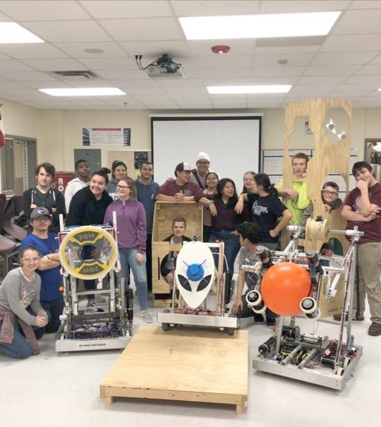 robotics teams posing with their robots that they built  