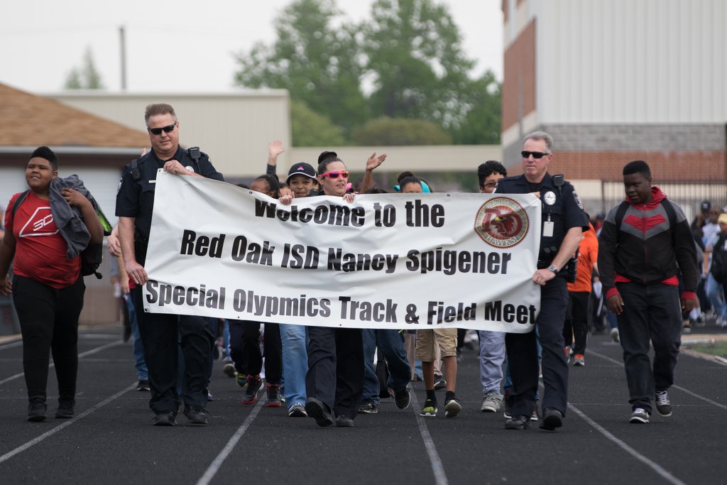 ROISD Police holding banner and leading Special Olympic Athlete Parade 